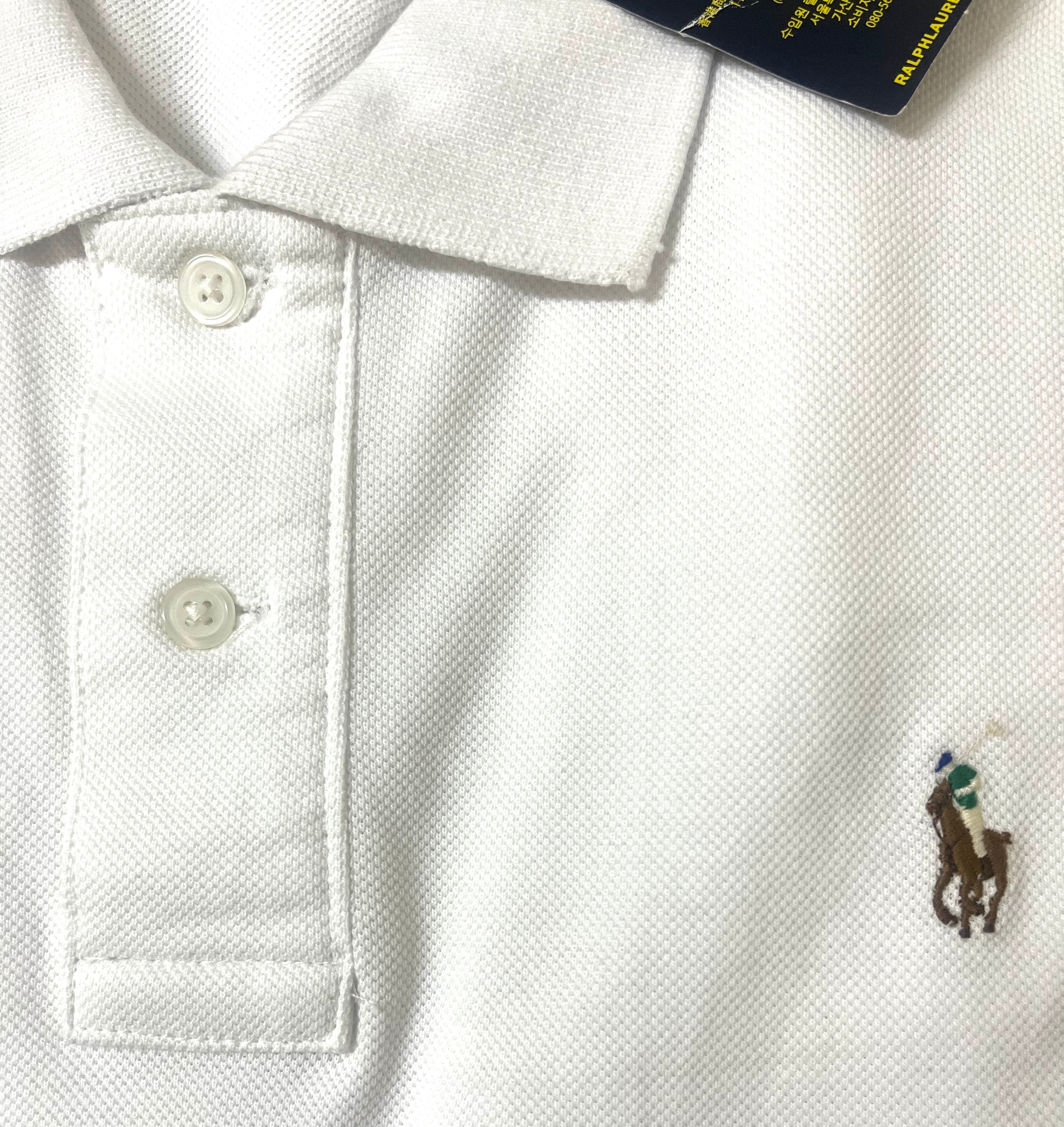 White polo shirt with embroidered logo on a tag